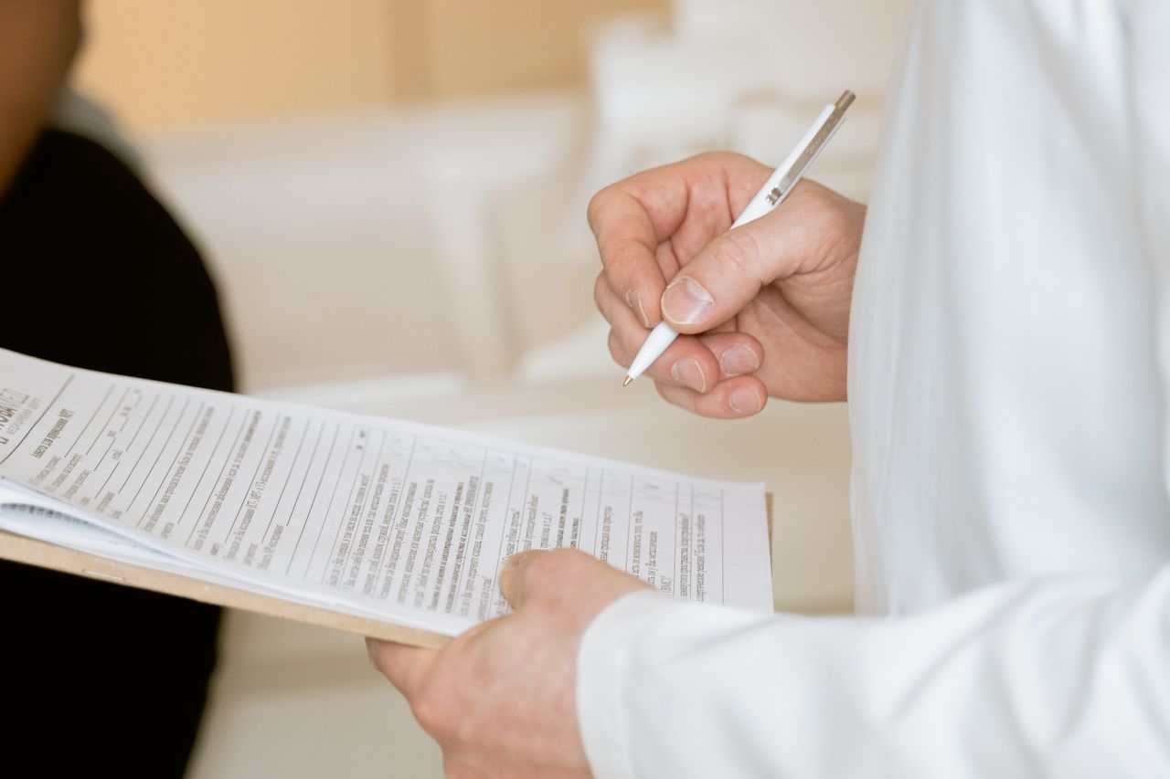 Crafting Captivating Headlines: Your awesome post title goes here A medical professional in a white coat examines a clipboard with patient documents.