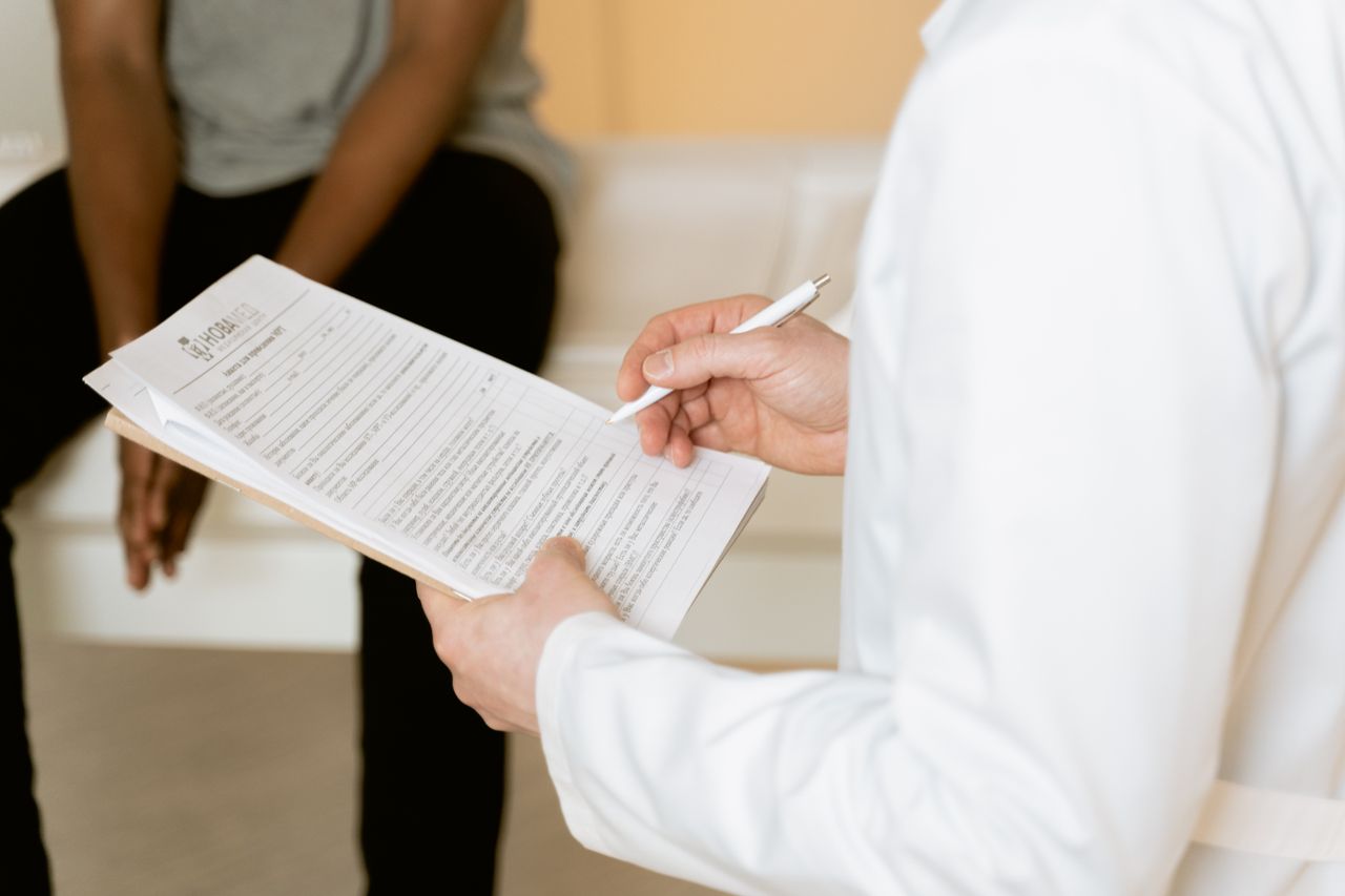 Services Healthcare professional reviews medical form during patient consultation in a clinic setting.